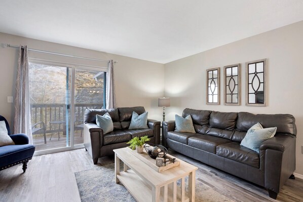 Open living space with TV, Full size sofa sleeper, and balcony access