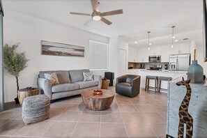 Bright, open living space. Living room features comfy seating and 55-inch Smart TV