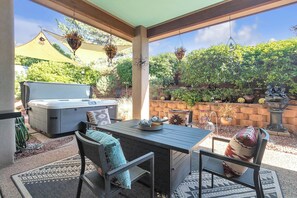 Covered patio with a gas BBQ and an outdoor dining area and a fire table