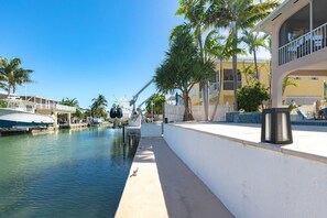 The dock out back extends out into the canal, offering a peaceful spot to enjoy the water, whether for lounging or docking a boat.