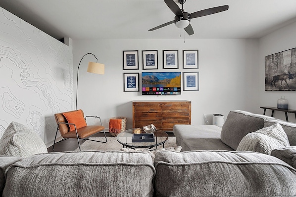 Large living room space with comfy sectional and smart TV