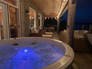 As night falls, relax in the glow of the hot tub with the tranquil sounds of the water just steps away, perfect for unwinding after a day of adventure.