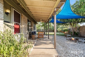 Gorgeous outdoor area with patio furniture, fire pit, hammock, corn hole and more