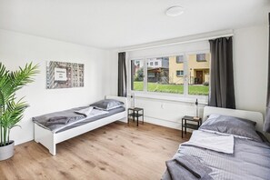 Gemütliches Schlafzimmer mit viel Licht. Rolladen sind vorhanden, zusätzlich noch Vorhänge für mehr Privatsphäre