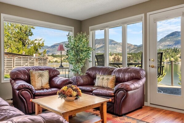 Living room with glorious views of the Rocky Mountains, gas-lit fireplace, cozy seating options & access to the first patio space.