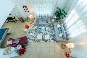 Open design, large living space, with inter-leading living and dining areas
Wall-to-wall windows look out over the patio – and on to the villa’s private swimming pool
Two, deep-cushion couches, in L-formation 