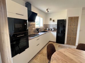 The modern kitchen is well equipped with multiple appliances 