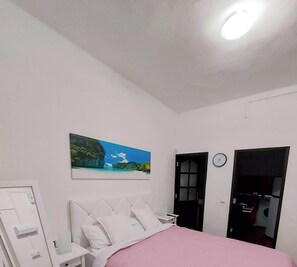 Dormitorio con cama de 150 cm y sabanas de algodón.