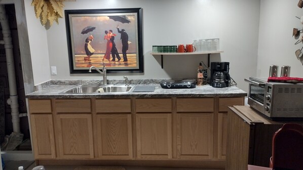 Fully stocked kitchen, sink, glasses, plates, towels, silverware, utensils, pans