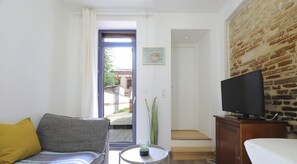 Espace séjour avec coin salon, tv et coin repas