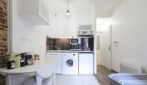 Espace séjour avec coin salon, tv, coin repas et kitchenette équipée