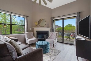 Open living space with sofa sleeper, Smart TV, and electric fireplace