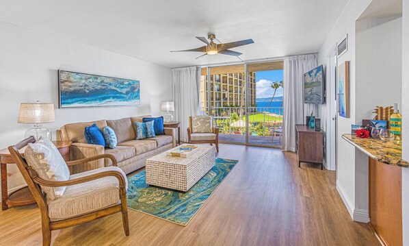 Relax in the cozy living room at Royal Kahana 213 with direct lanai access and views of the ocean and grounds.