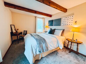 Minimalist queen bedroom featuring a dedicated workspace.