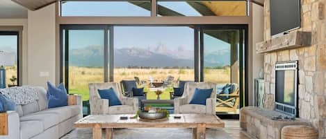 The large windows and sliders blend the outdoors and indoors to create a stunning living room.