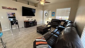 Large main living space w/ reclining sofa, Smart TV, Pinball, and games