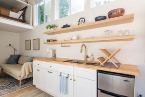 Full kitchen with electric stove top appliance and an air fryer! Easily stored when not being used to maximize counter space; tea & coffee available (but great coffee shops within walking distance)