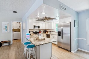 Bright and modern kitchen with a spacious counter—perfect for cooking, dining, and gathering!