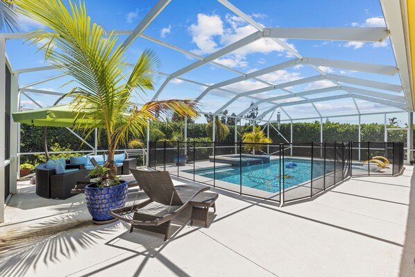 The private screened-in area has outdoor furnishings on the deck surrounding the resort-style pool.