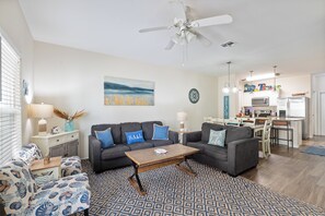 Relax in a sunlit living room where white walls, soft textures, and cozy seating create a calming and stylish atmosphere.