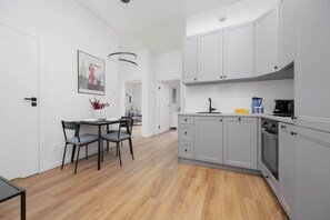 A compact kitchen with modern gray cabinetry, a built-in oven, and wooden countertops, offering both style and functionality in a small space.
