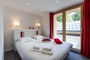 Rest in this bright and airy bedroom featuring a comfortable double bed and vibrant red accents. 