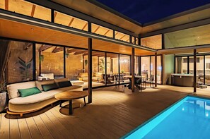 There is a terrace with sofas where you can relax and enjoy the view of the pool and lawn area.