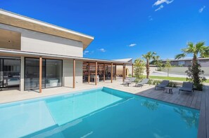 A luxurious space connected by a corridor surrounding the pool and fireplace