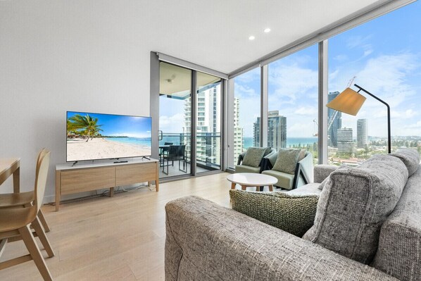 Spacious living room with a high ceiling, floor-to-ceiling windows, and an amazing Southeastern coastline view.