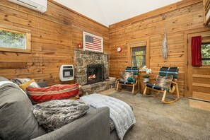 In the living room, you’ll find our grey sectional, two rocking chairs, and a large natural wood-burning fireplace.