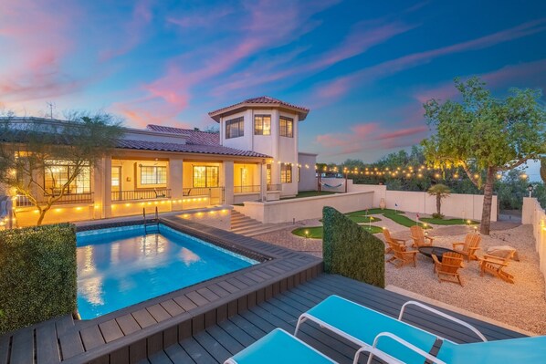 This luxurious two-story house, with its inviting swimming pool and cozy fire pit, is the perfect retreat for enjoying twilight moments. The warm glow from the windows and the serene outdoor setting make it an ideal spot for relaxation and entertaining. 🌅🏡🔥