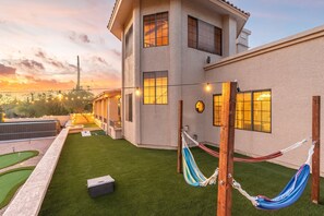As the sun sets, this backyard transforms into a serene oasis with a mini-golf course and hammocks, perfect for unwinding and enjoying the twilight glow. 🌅🏡⛳