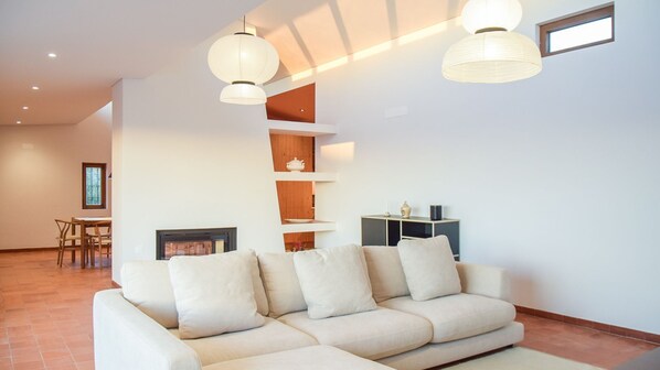 A spacious living room with a comfortable sofa, a cable TV, and patio access. #sesimbra #decoration #home #airbnb #portugal