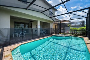 Pool and spa view showing screened enclosure and child safety fence