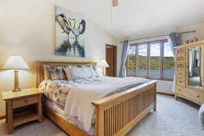 Wake up to peaceful lake views in this cozy and inviting master bedroom.