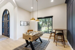 The Game Room featuring a Foosball table, designer furnishings, and a small dining table with seating for 2 guests.