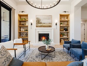 Second Living Area with designer furnishings, a fire place, and access to the backyard patio.