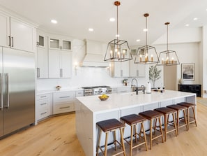 Fully equipped kitchen with stainless steel appliances, a Scotsman Ice Maker, and bar seating for 6 guests.