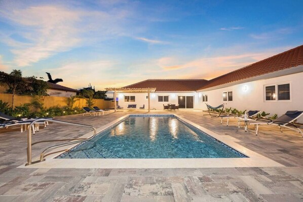 The pool glows softly under the evening sky.