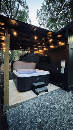 Covered hot tub with TV for music, game day, or movies.