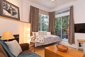 Showing the BRIGHT natural light and the glass door to private sundeck. TV mounted on wall
