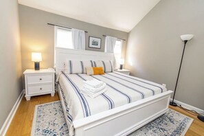 Primary bedroom with king bed and cathedral ceiling
