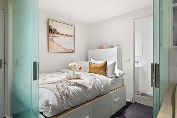 A bedroom area with a double sized bed & plush pillows.
