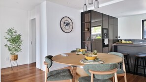 The dining room at Blissful Suite features a stylish table with an open kitchen in the background, blending modern elegance with convenience. #fullyequippped