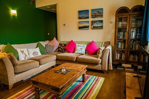 Living room with corner sofa, coffee table, bookcase