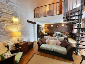 Sofa, armchair, spiral staircase to mezzanine