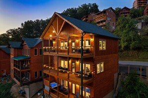 Three levels of outdoor deck sparkle under the glow of string lights.