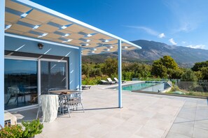 Poolside table on a patio overlooking the pool area and property view