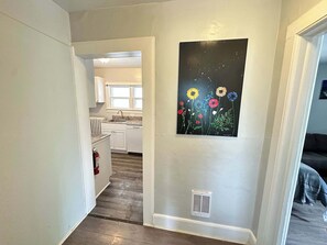 Front foyer, hallway leads to the kitchen on the left and living area on the right.