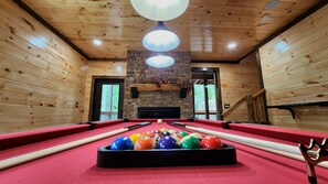 Game room with solid wood and leather pockets pool table and electric fireplace